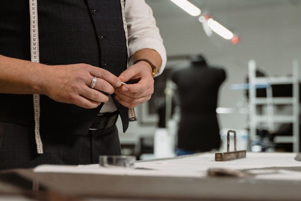 Tailor marking fabric with chalk and a tape measure