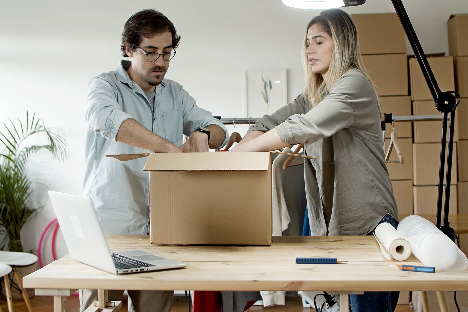 Team packing folded garments into a carton for private-label shipment