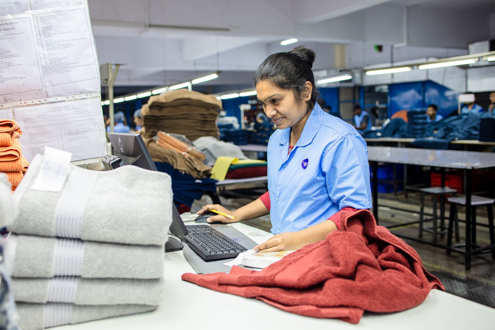 Factory worker checking fabric against production paperwork
