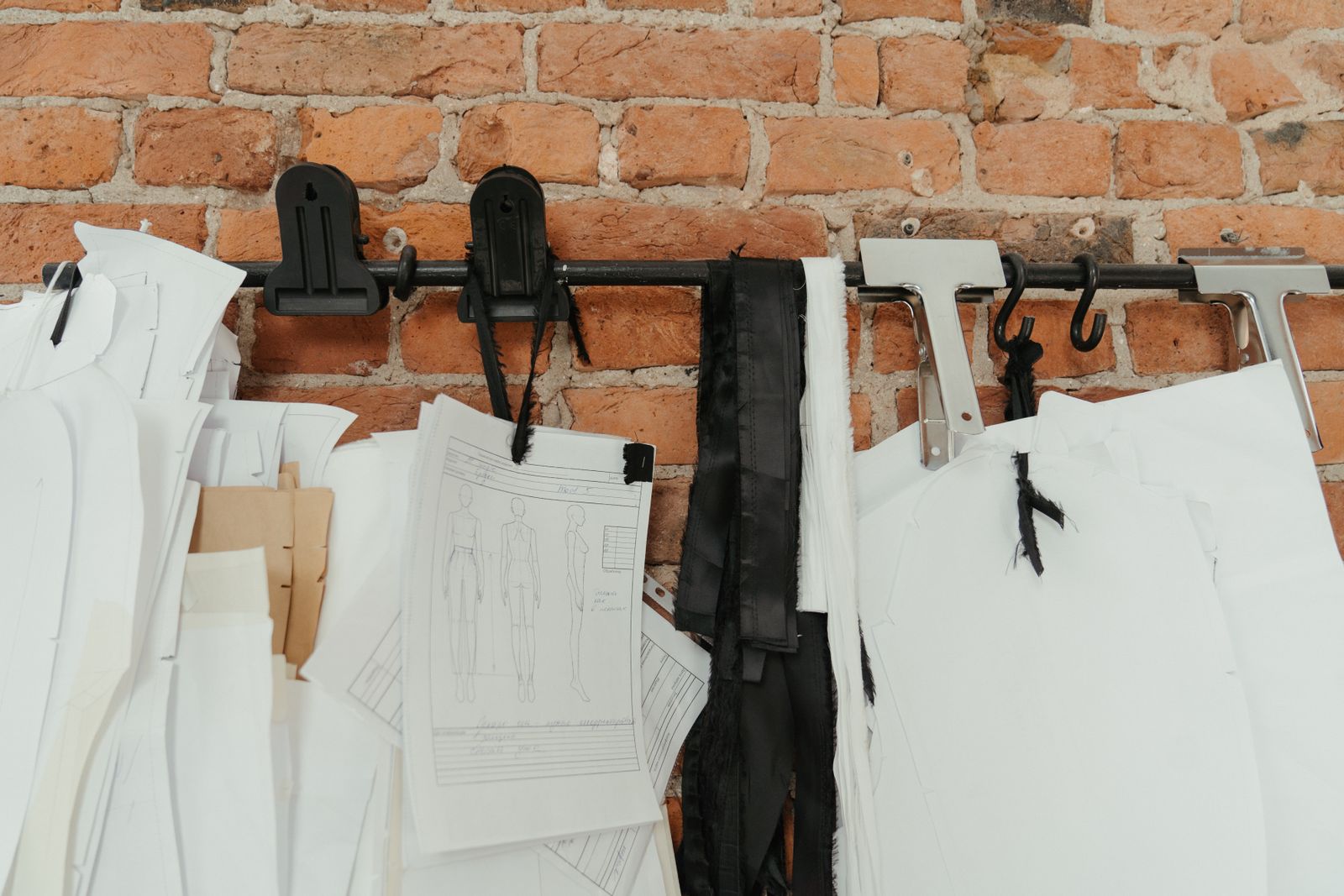 Sewing patterns and garment sketches hanging on a rail