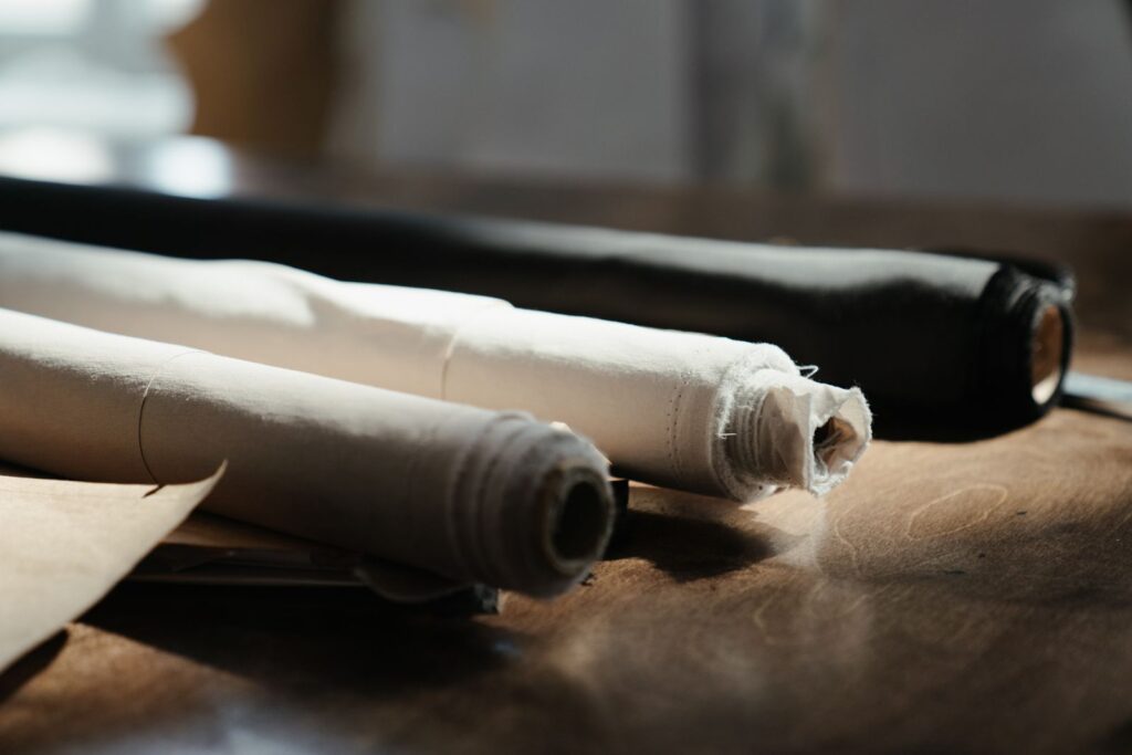 Rolls of woven fabric on a wooden work table