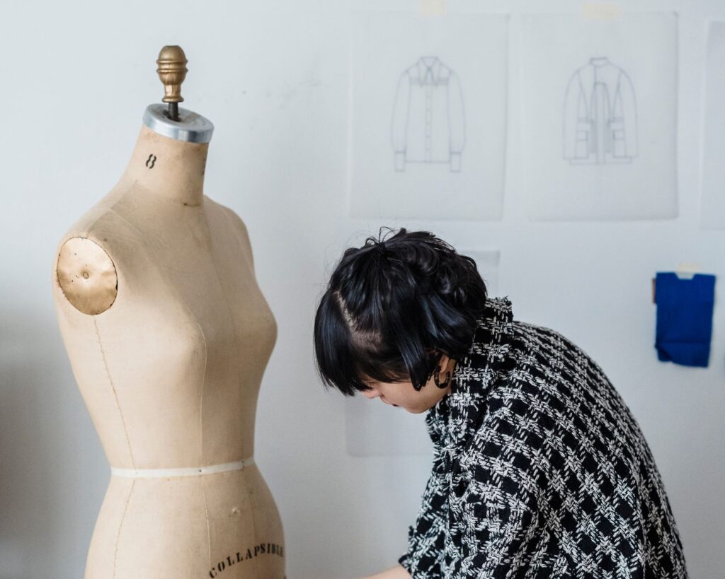 Designer measuring a dress form with a tape in a tailoring studio