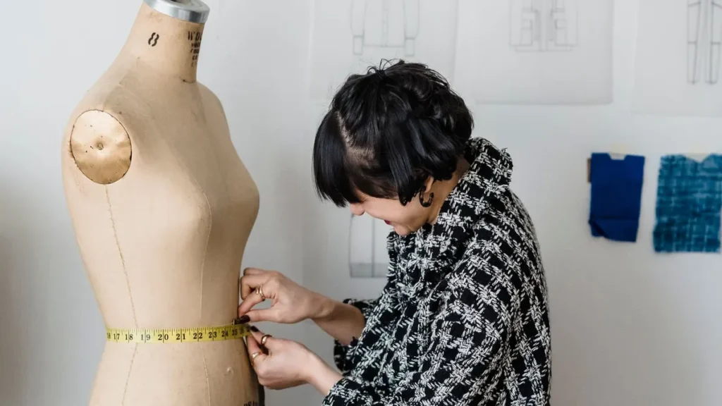 Seamstress measuring a garment waist on a dress form