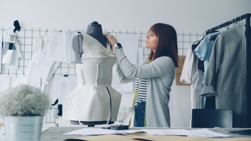 Fashion designer adjusting fabric on a dress form during woven sample development